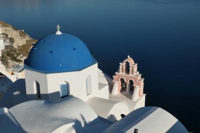 白い家と青ドーム教会が絶壁上に連なるサントリーニ島