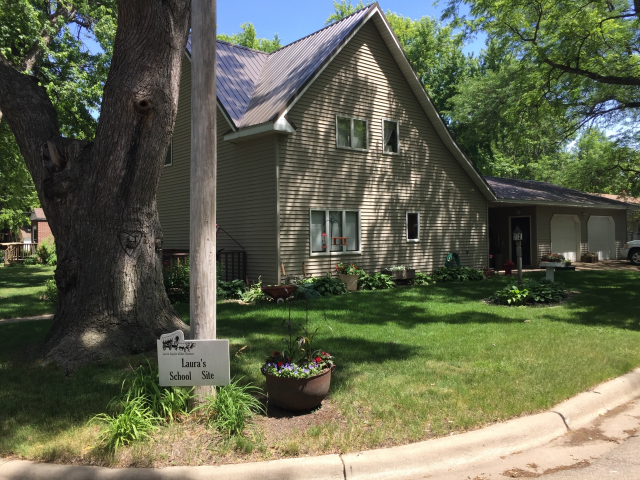 『ミネソタ州 ウォルナット グローブ － 今では緑が豊富な住宅地となり、ローラの学校跡地やとうさんのブーツのお金を寄付した教会の鐘』ミネソタ州