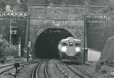 国鉄時代1967年の丹那トンネル入口（来宮口）
まだ縦書きの木製トンネル標で「丹那隧道」と書かれていることがわかります。
上部には鉄道大臣･内田信也揮毫の「丹那隧道」の扁額があります。
当時丹那トンネルは東京鉄道管理局（東鉄）の所管で、JR化後に境界が函南口から熱海口に変更され、トンネルはJR東海の所管に変わりました。
大目玉の111系が懐かしいですね。
【５－１】