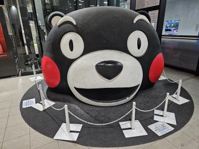 おはよう！くまモン！<br />熊本駅の新幹線改札内にどーんと居座るくまモンさん。<br />この顔を見ると、旅に出る実感が沸きます。<br />もし、地中に体が埋まっているとしたら、超巨大なくまモンだよね。世界を守る最強兵器だったりして。<br />そんな妄想をしながら、始発の新幹線で出発です、