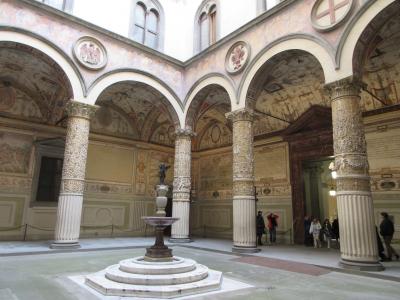 15世紀後半にミケロッツォの設計した中庭<br /><br />先を急いでしまったためゆっくりと見れませんでしたが、回廊の柱の豪華なこと！白と金の漆喰だそうです。回廊奥の天井もきれい、ウフィツイ美術館の天井にも似ています。<br /><br />受付への入り口を写したため中央のヴェロッキオ作”イルカを抱いたキューピット像”（レプリカ）がよそを向いていましたが、この奥にチケット売り場がありフィレンツェカード所有者は専用の窓口でレシートのようなものを発行してもらい、それが入場券でした。<br /><br />この1階にはMuseoとTorreというふたつの入り口があるので、まずMuseoから。<br /><br />