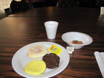 朝食、マフィンと卵と黒いのはソーセージです