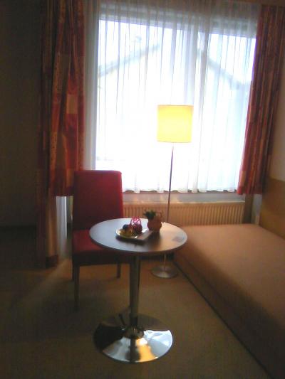 テーブル（上にフルーツと花）いす、ソファー、外はバルコニーが