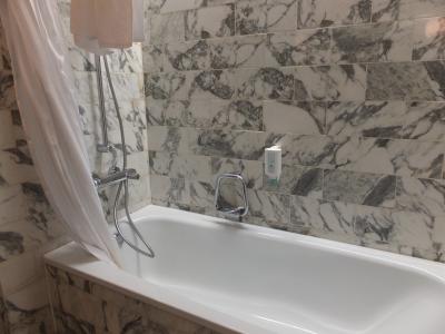 広いバスタブと、奥には扉付きのトイレがあります