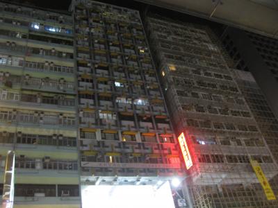 赤い看板の左側の古いビル（15階建て）