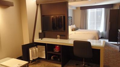 リビングとベッドルームの仕切りはテレビと作業台と冷蔵庫