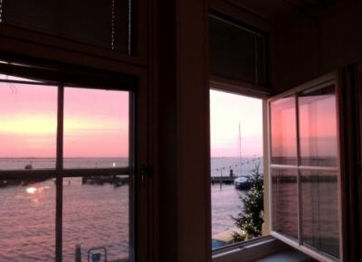 部屋からピンクに染まる夕景を眺める