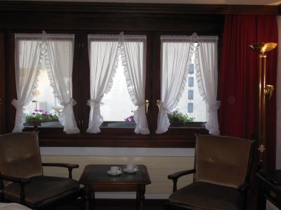 ベッドの脇のテーブルと椅子。カーテンの後ろがベランダ。