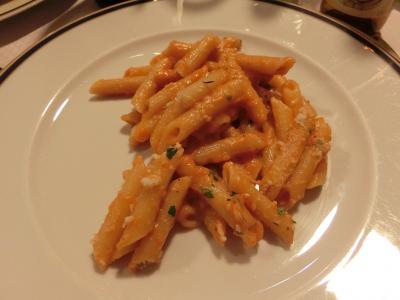 ディナー料理は、ペンネ、サラダ、スライス豚肉