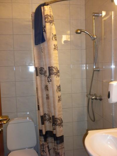 怪しげな漢字を図案化したカーテンが下がる超狭いシャワールーム