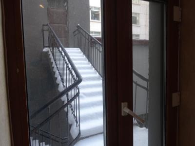 窓の外は隣の建物の入口だった