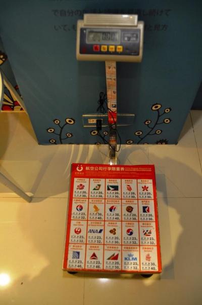 ロビーに計量計があり、航空会社ごとの預け荷物重さ制限を明示