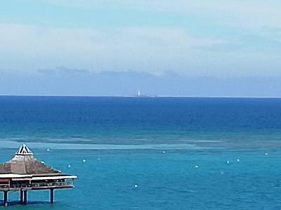ベランダから水平線上に見えるアメデ島灯台