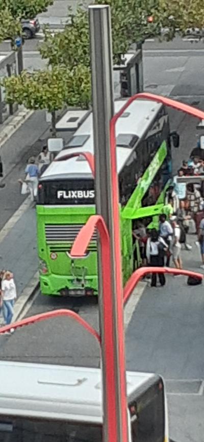 部屋からバス停に停まるFLiXバスの緑の車体が見えます。