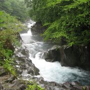 岩肌が特徴的な渓流と、地蔵たち