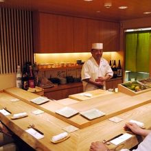 テーブル一つと、たも材のカウンター席の小さなお店　