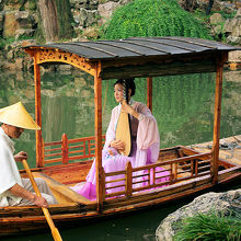 留園の池に浮かぶ小舟と中国琵琶を爪弾く女性