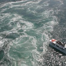 渦潮の横を通過する汽船