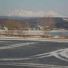 融雪で池のようになった田畑と大雪山系