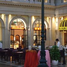 お店の入口といつも青空のテラス席（天井画ですから）。