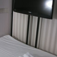 足元のテレビと着替えや歯ブラシ、タオル一式