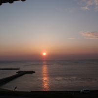 窓から見える海に沈む夕陽