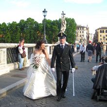 城の前では、チェロ弾きのパフォーマーと結婚式の前撮りが...