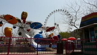 市民の憩いの場的な公園、でも、遊園地のような子供向けの乗り物もあり、草木も多い。