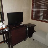 テレビの奥に一人掛けソファとミニテーブル。