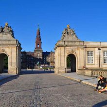 正門わきでカップルが話し込み、午後の陽光もやさしかった