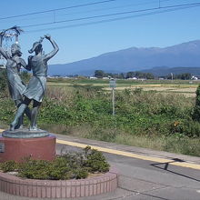ホーム上の銅像と鳥海山