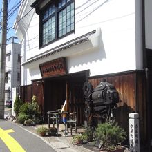 白壁の蔵のような造り、正面にはカメラのオブジェ。