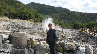 山肌の岩間や地面の裂け目から蒸気が噴出す