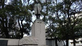 日本銀行を背にして立っています。