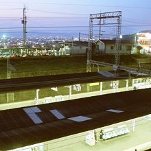 駅北口。2面4線堀割ホームの向こうに、大阪平野の夜景