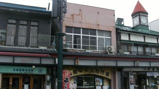 商店街にあるかわいらしい赤いとんがり帽子の時計がある建物