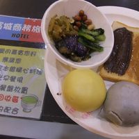 朝食。お粥・パン・饅頭・おかず・容器は紙製