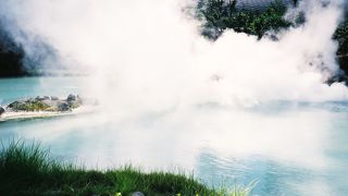 白濁した池から蒸気が上がっています