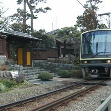 門の前を江ノ電走る