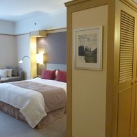 ベッドの空間の横にクローゼットとスーツケースを置ける台あり