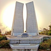 夕方の太陽を背にした三瓶町下泊の魚霊塔 （ぎょれいとう）