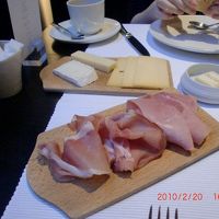 木のトレイに数種類のハムやチーズなどが