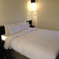 ベッドはキングサイズ。リビングと同じ壁掛テレビあり。