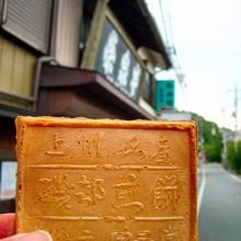 買った煎餅を早速開封して撮影しました。背景が店の看板