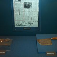 犯人逮捕を伝える当時の新聞と、被害者めがね、凶器の肉切り包丁