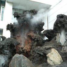 ビルの前で湯気が立ちこめていて、温泉街の風情が感じられます。