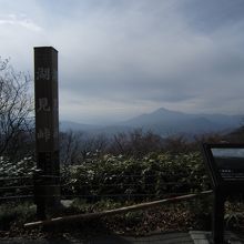 湖見峠の標柱で、遠方は磐梯山、右側には説明盤があります