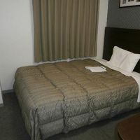 ベッドはセミダブルで広いです。カーテンの先は新山口駅舎です。