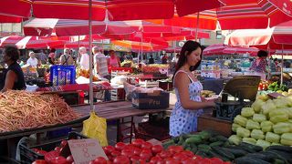 鮮やかな赤いパラソルが青空に映えるカラフルな市場