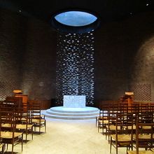 穏やかで暖かみのある礼拝室と天窓から祭壇を照らす光の柱